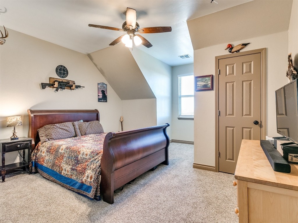 2350 Gina Court, Guthrie, OK 73044 carpeted bedroom featuring vaulted ceiling and ceiling fan