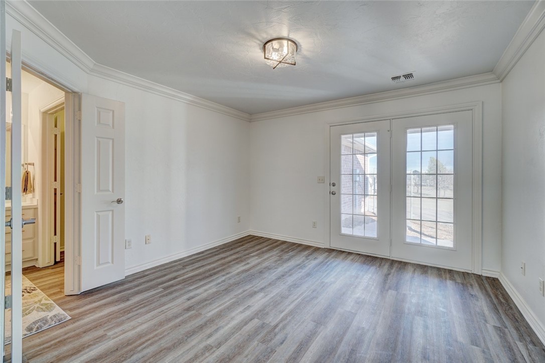 300 Glen Drive, Yukon, OK 73099 unfurnished room with crown molding and light hardwood / wood-style floors