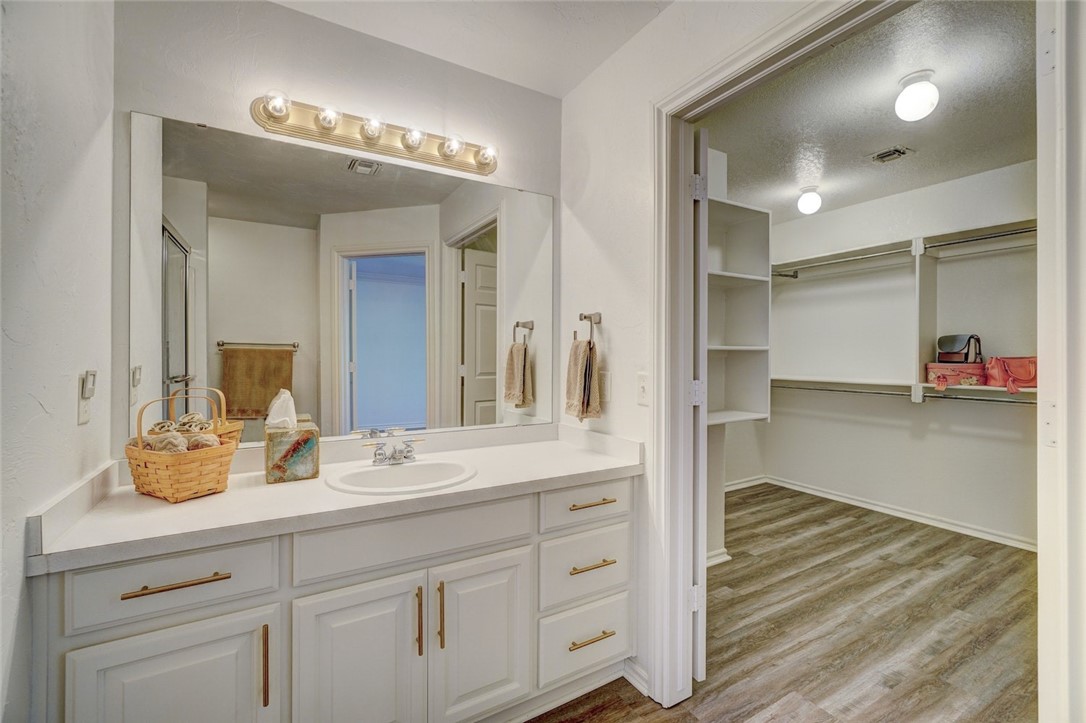 300 Glen Drive, Yukon, OK 73099 bathroom with hardwood / wood-style floors, vanity, and a textured ceiling