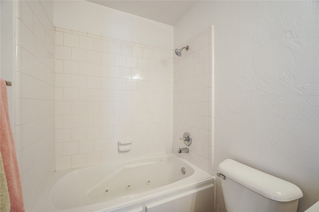 300 Glen Drive, Yukon, OK 73099 bathroom featuring toilet and tiled shower / bath combo