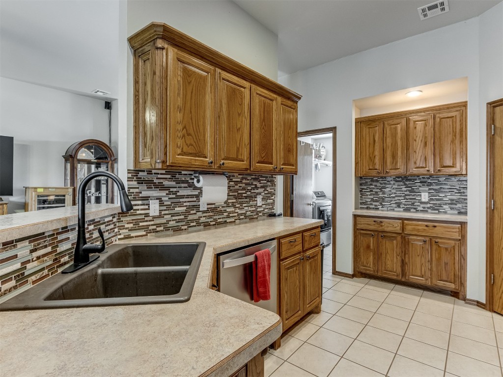 1161 Mill Ridge Drive, Blanchard, OK 73010 kitchen featuring backsplash, dishwasher, light tile floors, and sink