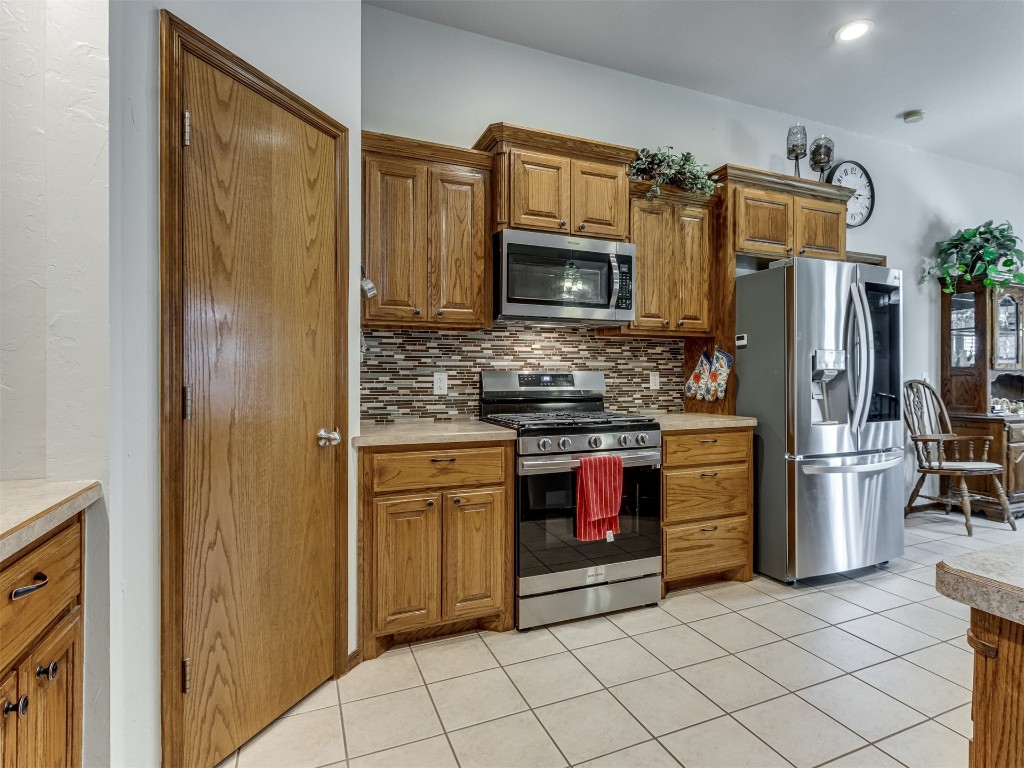 1161 Mill Ridge Drive, Blanchard, OK 73010 kitchen with tasteful backsplash, light tile floors, and stainless steel appliances