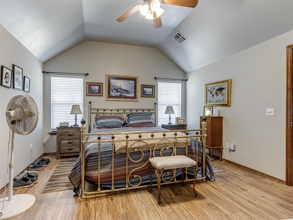 1161 Mill Ridge Drive, Blanchard, OK 73010 bedroom featuring lofted ceiling, light wood-type flooring, and multiple windows