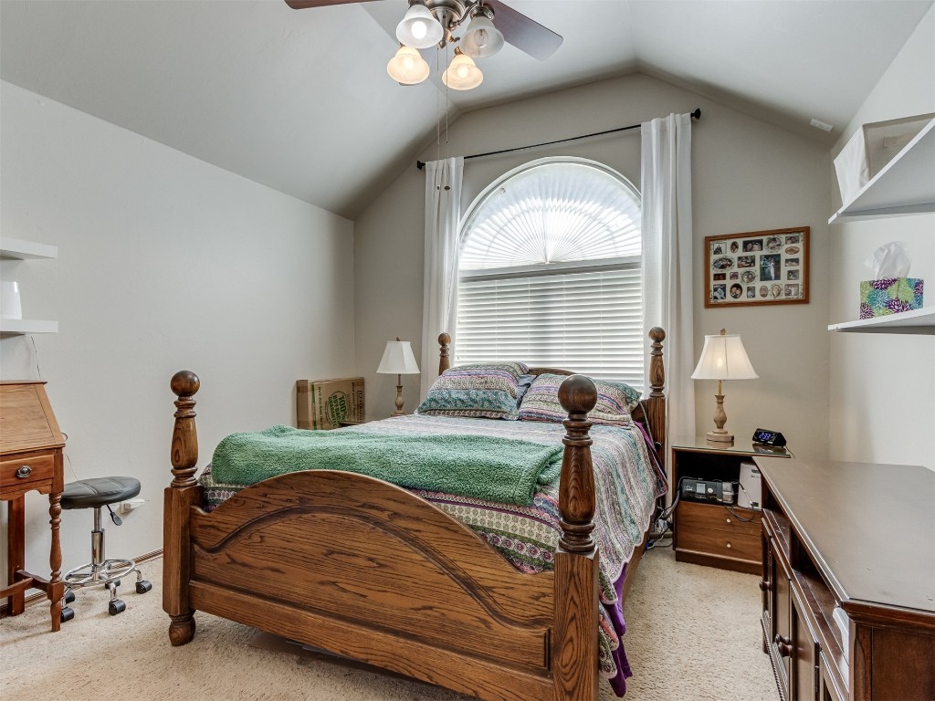 1161 Mill Ridge Drive, Blanchard, OK 73010 carpeted bedroom featuring ceiling fan and vaulted ceiling