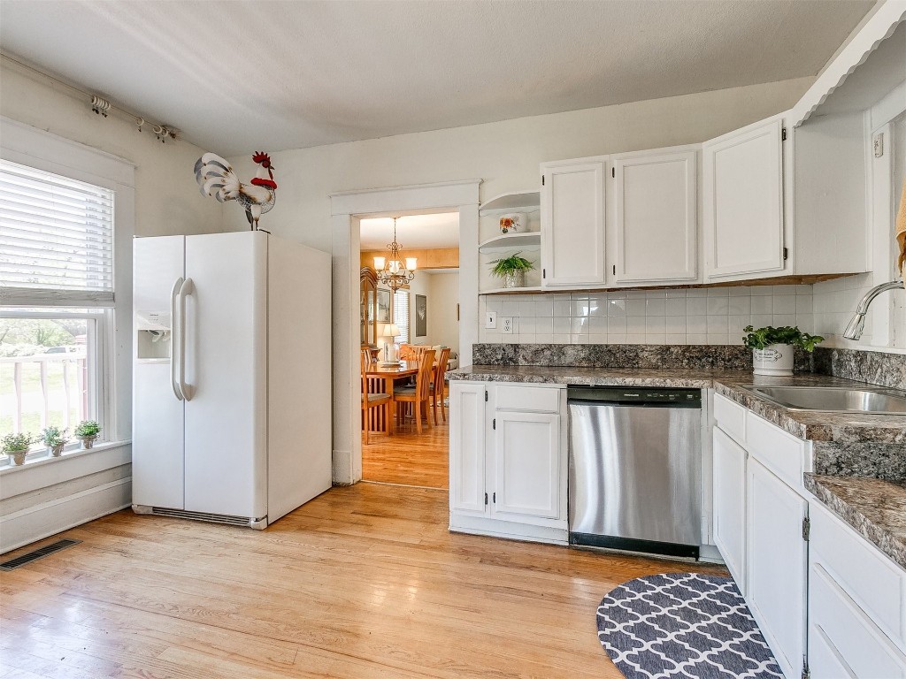 1623 W Oklahoma Avenue, Guthrie, OK 73044 kitchen featuring white fridge with ice dispenser, backsplash, dishwasher, and white cabinetry