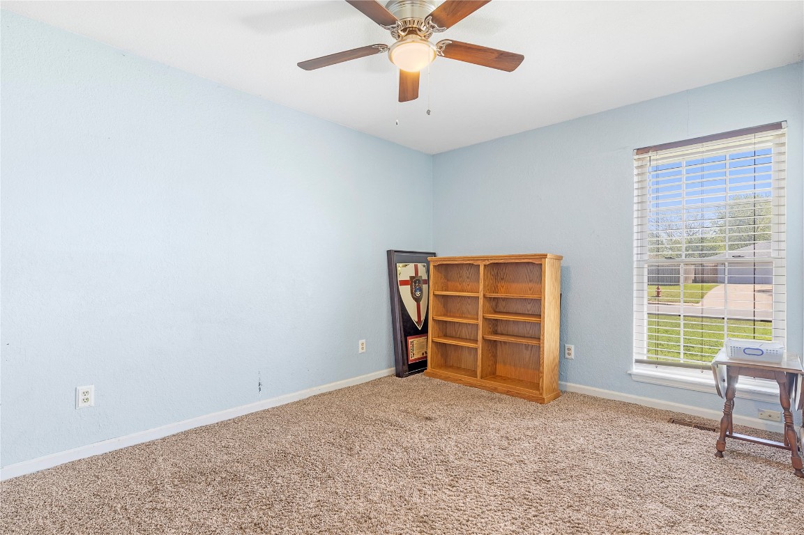 1601 Whispering Creek Drive, Edmond, OK 73013 carpeted empty room with ceiling fan