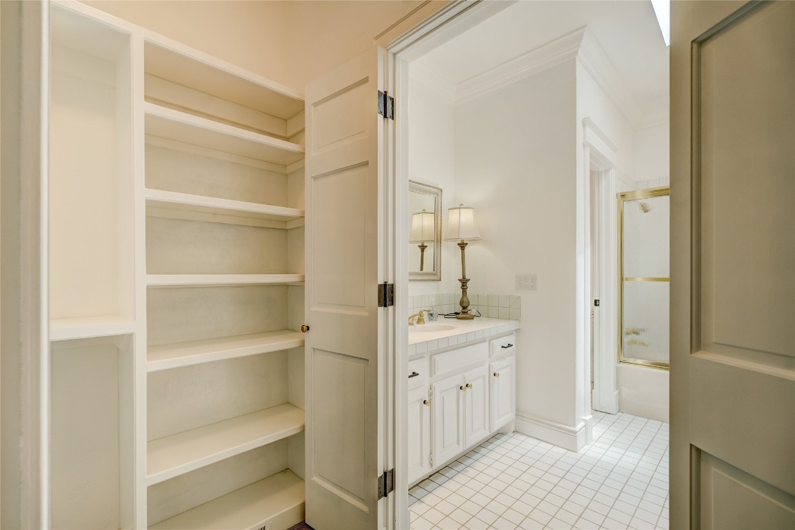 6324 Harden Drive, Oklahoma City, OK 73118 bathroom with tile flooring, ornamental molding, vanity, and shower / bath combination with glass door