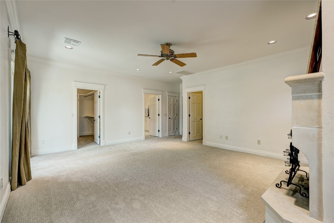 6324 Harden Drive, Oklahoma City, OK 73118 spare room featuring light colored carpet, ceiling fan, ornamental molding, and a barn door