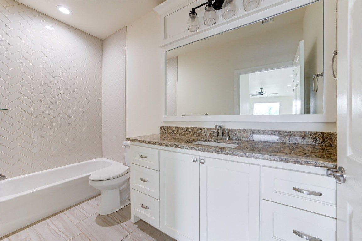 12712 Bristlecone Pine Boulevard, Oklahoma City, OK 73142 full bathroom featuring tile flooring, ceiling fan, tiled shower / bath, toilet, and vanity