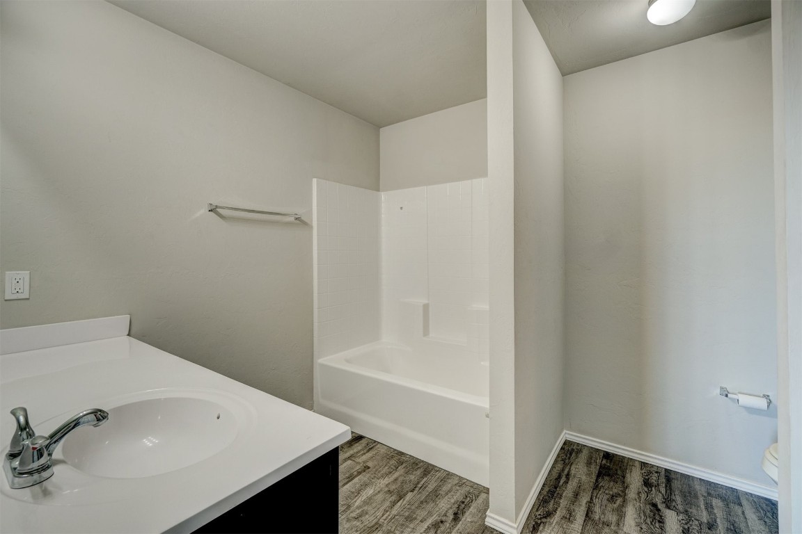 10005 Ruger Road, Yukon, OK 73099 full bathroom featuring wood-type flooring, vanity, toilet, and bathing tub / shower combination