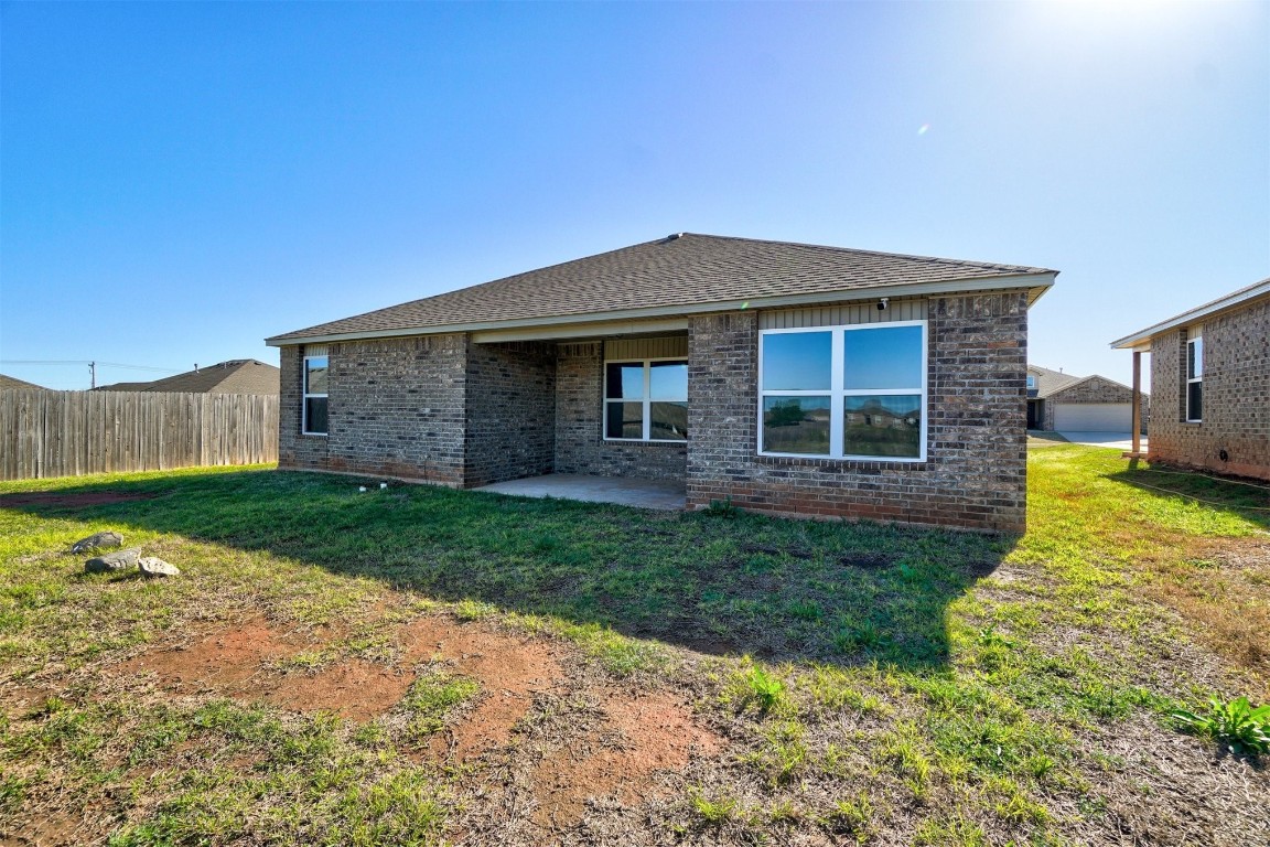 10005 Ruger Road, Yukon, OK 73099 back of house featuring a patio and a lawn