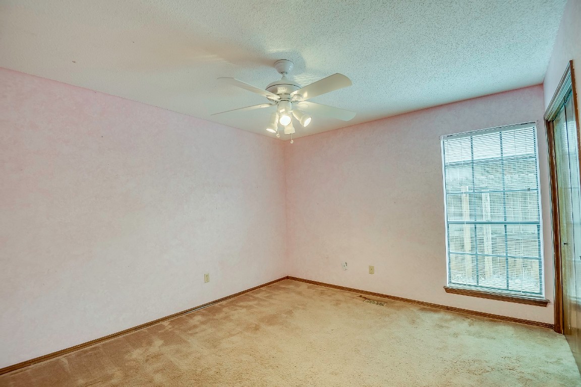 6628 Evergreen Canyon Road, Oklahoma City, OK 73162 spare room featuring light colored carpet, a textured ceiling, and ceiling fan