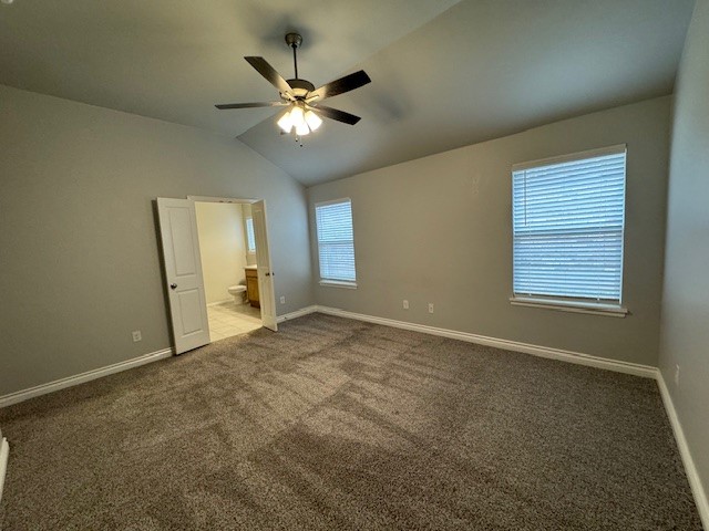 405 Vista Drive, Yukon, OK 73099 unfurnished bedroom with ensuite bath, light colored carpet, ceiling fan, and multiple windows