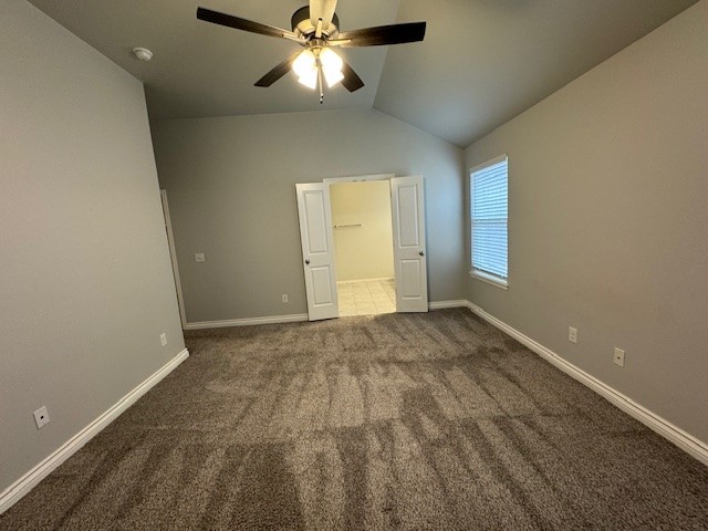 405 Vista Drive, Yukon, OK 73099 unfurnished bedroom with vaulted ceiling, dark colored carpet, and ceiling fan