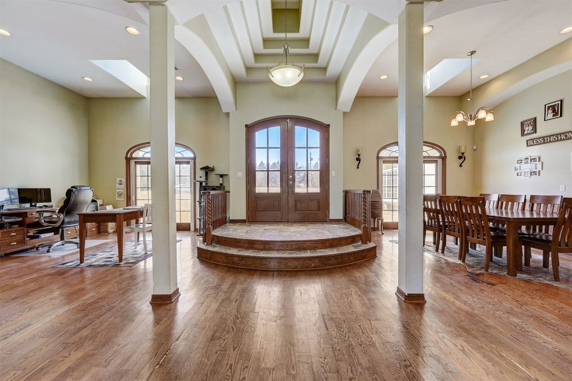 5608 E 68th Street, Stillwater, OK 74074 foyer entrance with french doors, a high ceiling, hardwood / wood-style floors, a chandelier, and ornate columns