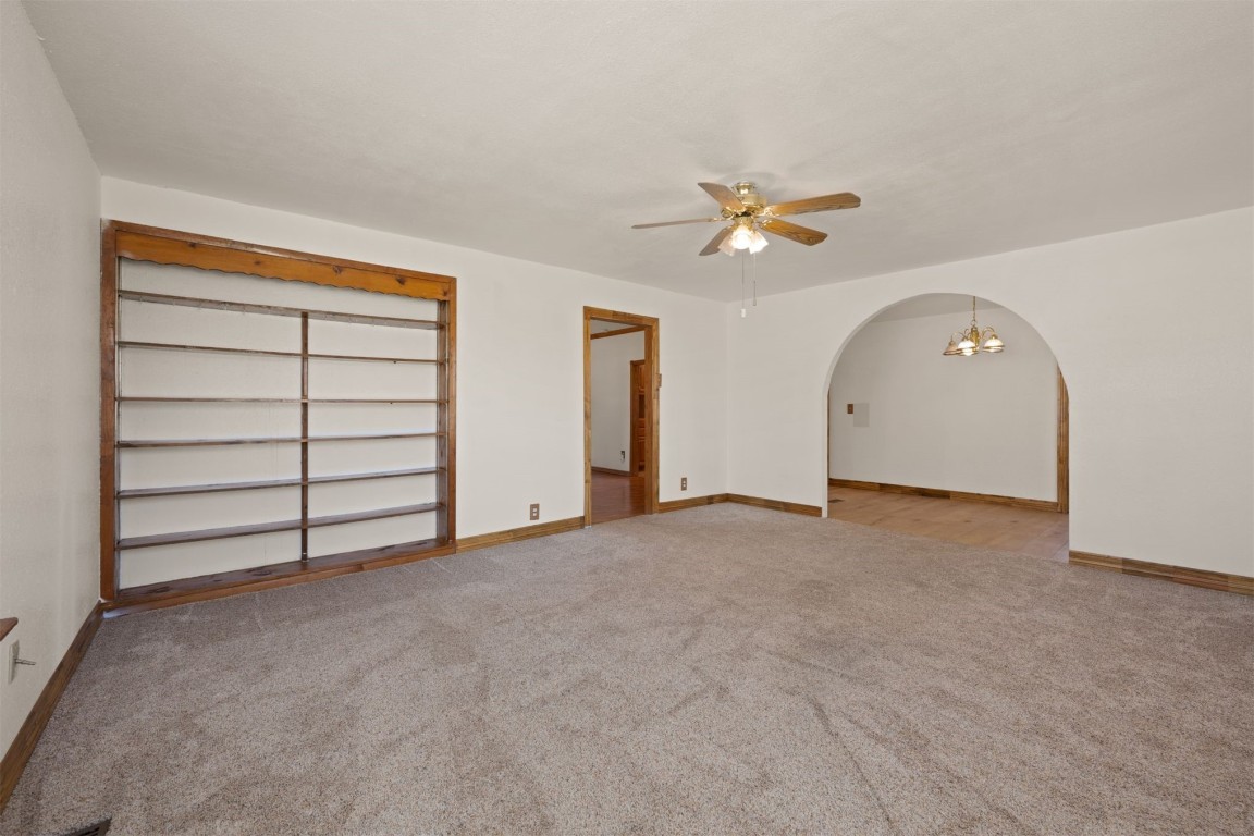 1902 W Noble Avenue, Guthrie, OK 73044 carpeted spare room featuring ceiling fan with notable chandelier