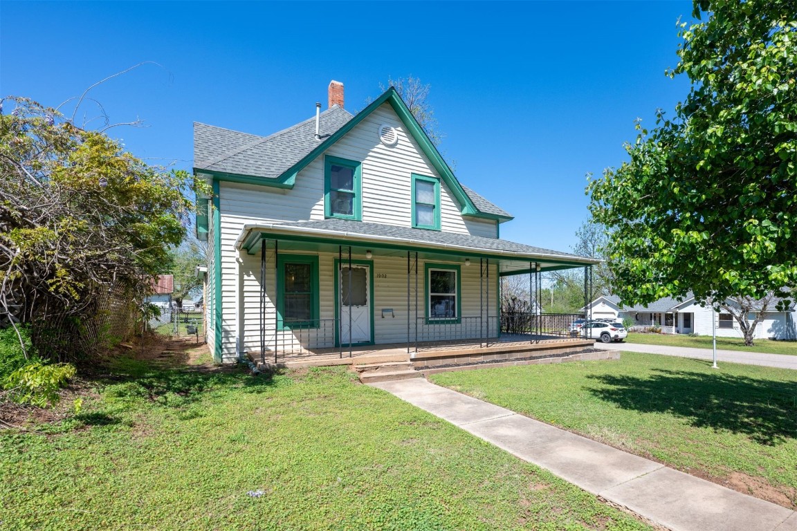 1902 W Noble Avenue, Guthrie, OK 73044 farmhouse inspired home featuring a front yard and a porch