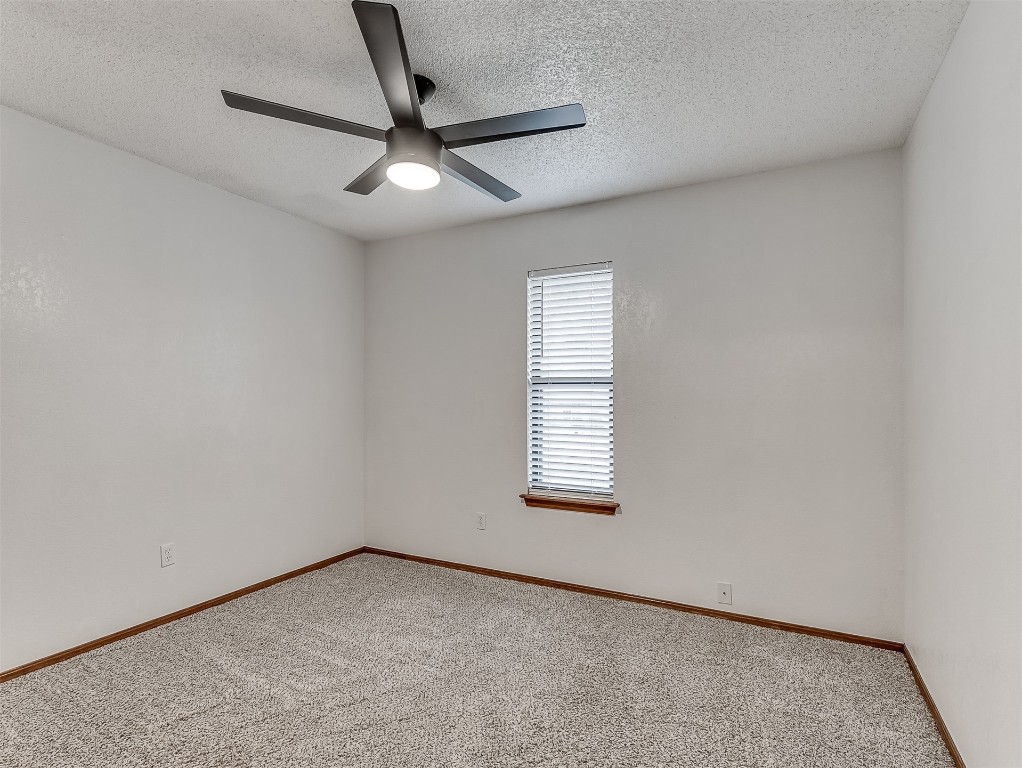 1521 NE 3rd Street, Moore, OK 73160 carpeted spare room featuring ceiling fan and a textured ceiling