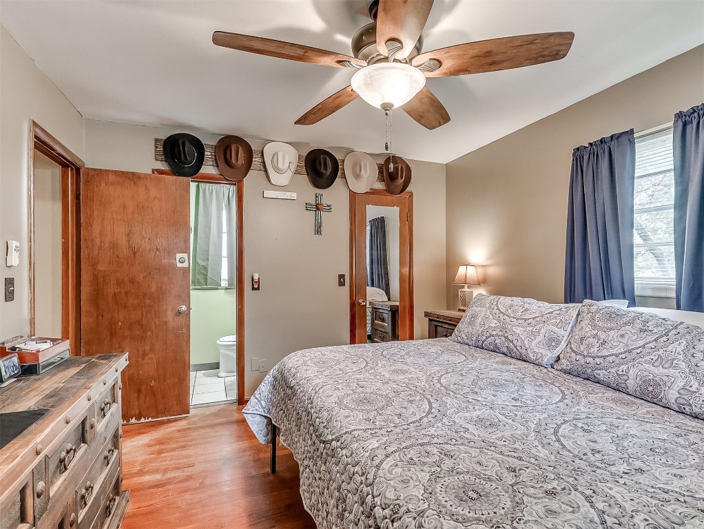639 Ridgecrest Road, Edmond, OK 73013 bedroom featuring ensuite bath, ceiling fan, and hardwood / wood-style flooring