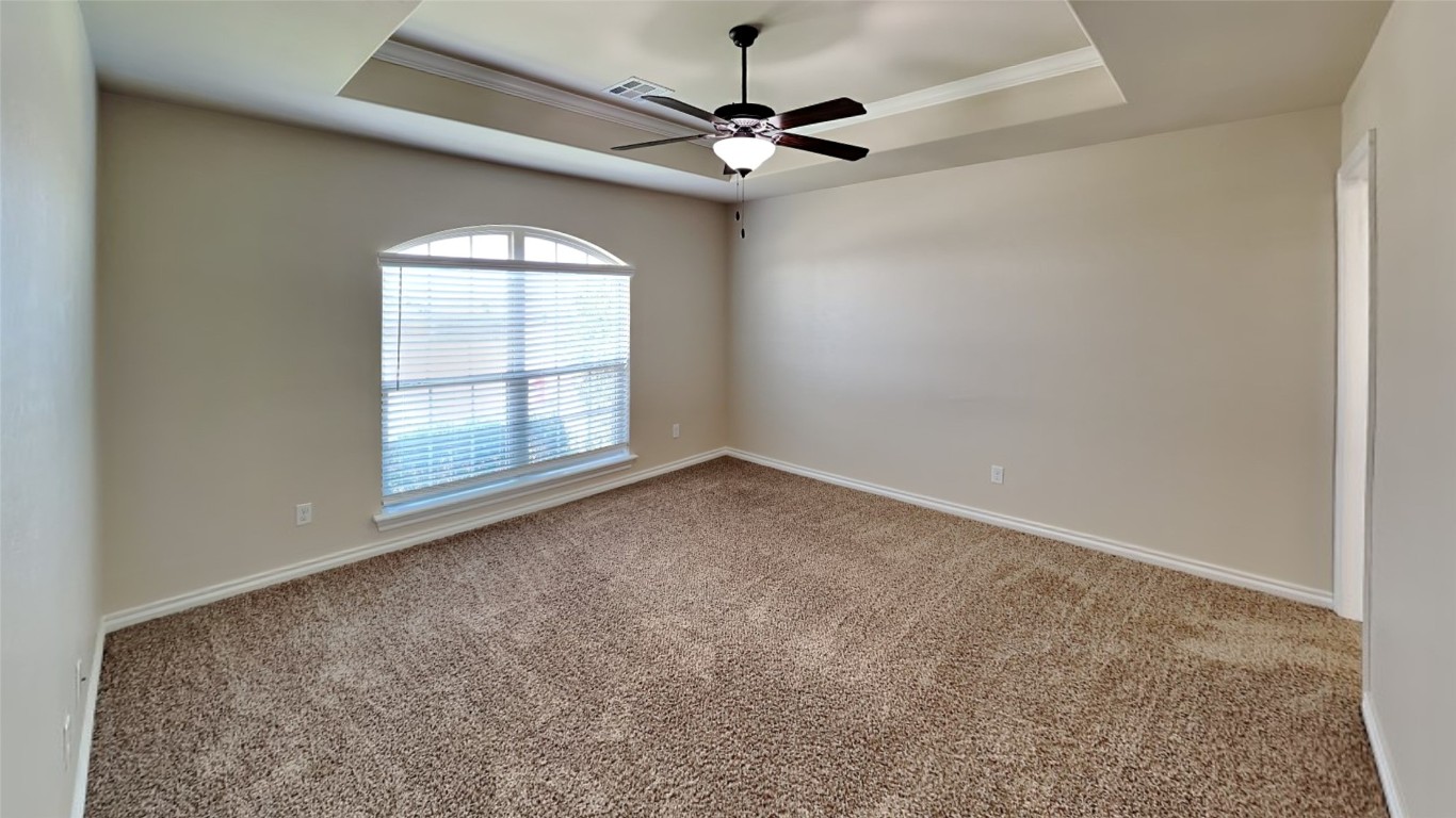 18220 Camborne Avenue, Edmond, OK 73012 carpeted spare room featuring ceiling fan and a raised ceiling