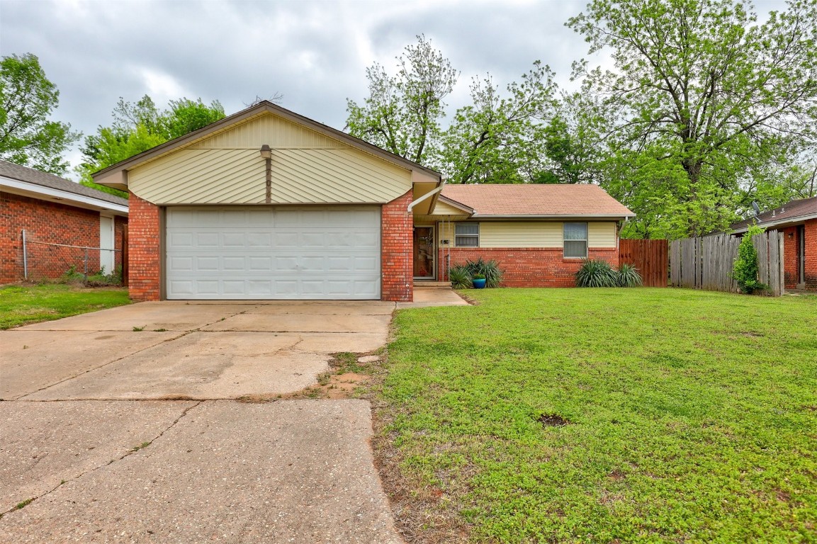 704 Juniper Avenue, Midwest City, OK 73130 ranch-style home with a front yard and a garage