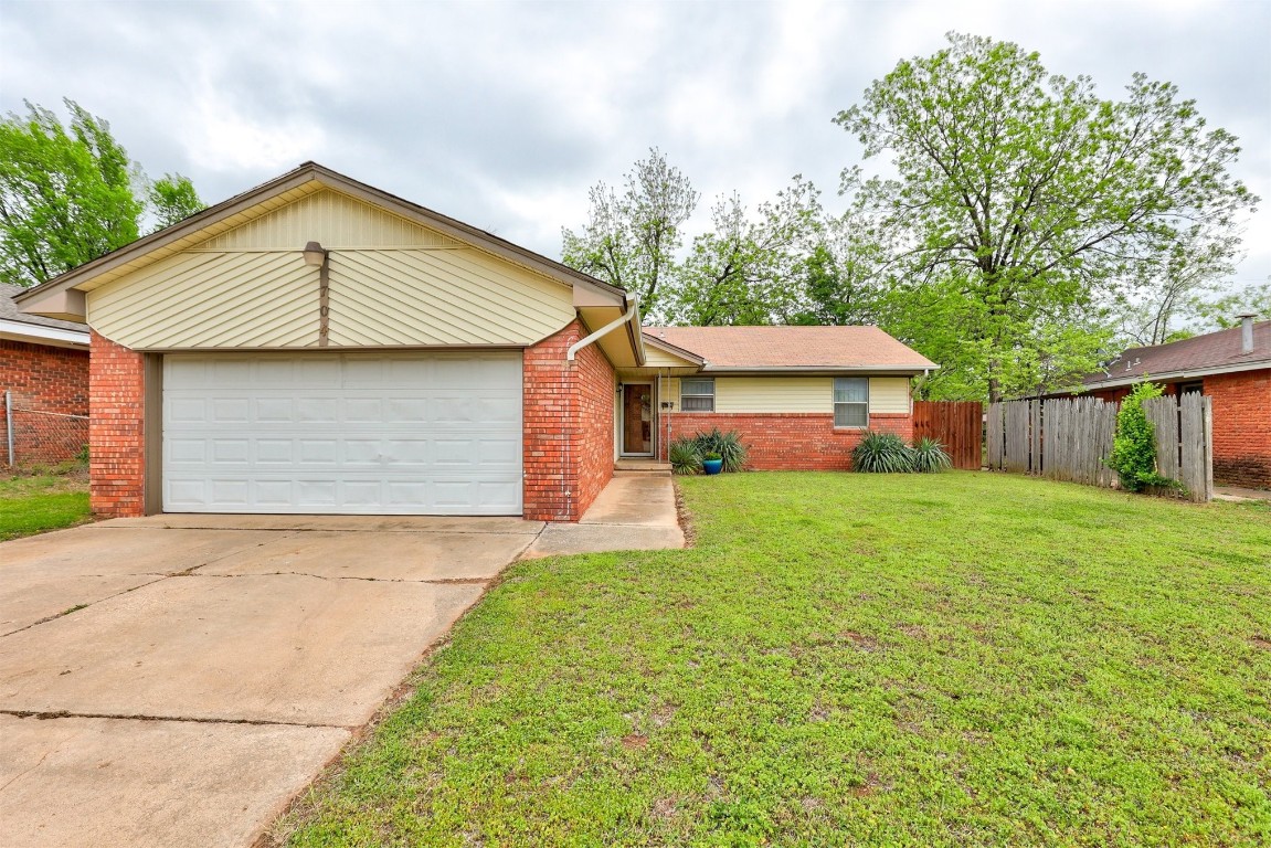 704 Juniper Avenue, Midwest City, OK 73130 single story home featuring a front yard and a garage