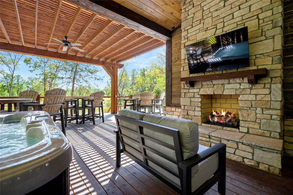 41 Oak Creek Trail, Broken Bow, OK 74728 wooden terrace featuring ceiling fan and an outdoor living space with a fireplace