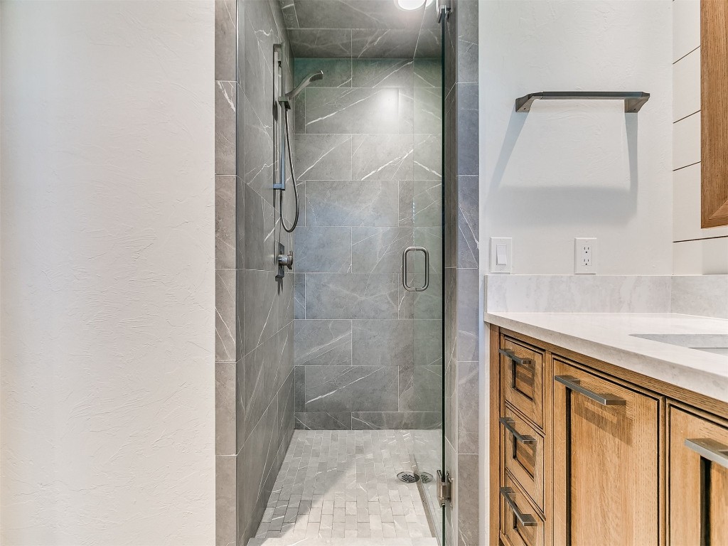 609 S Chloe Lane, Mustang, OK 73064 bathroom featuring walk in shower and vanity