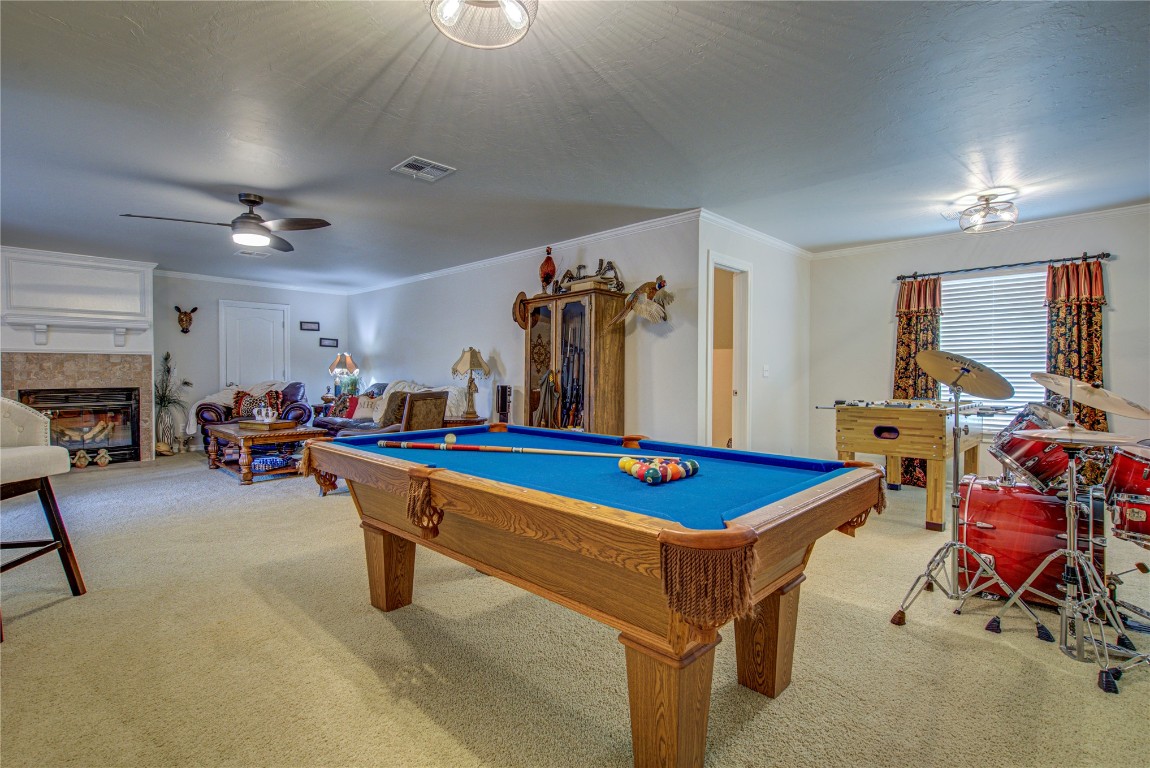 4209 Heavenfield Court, Edmond, OK 73034 rec room featuring light colored carpet, ceiling fan, billiards, and a tiled fireplace