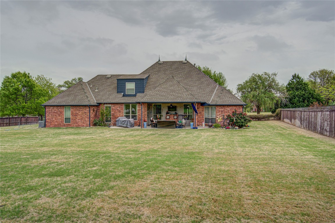 4209 Heavenfield Court, Edmond, OK 73034 back of house with a patio area and a lawn
