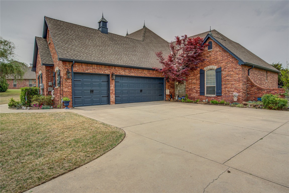 4209 Heavenfield Court, Edmond, OK 73034 view of front facade featuring a garage and a front lawn