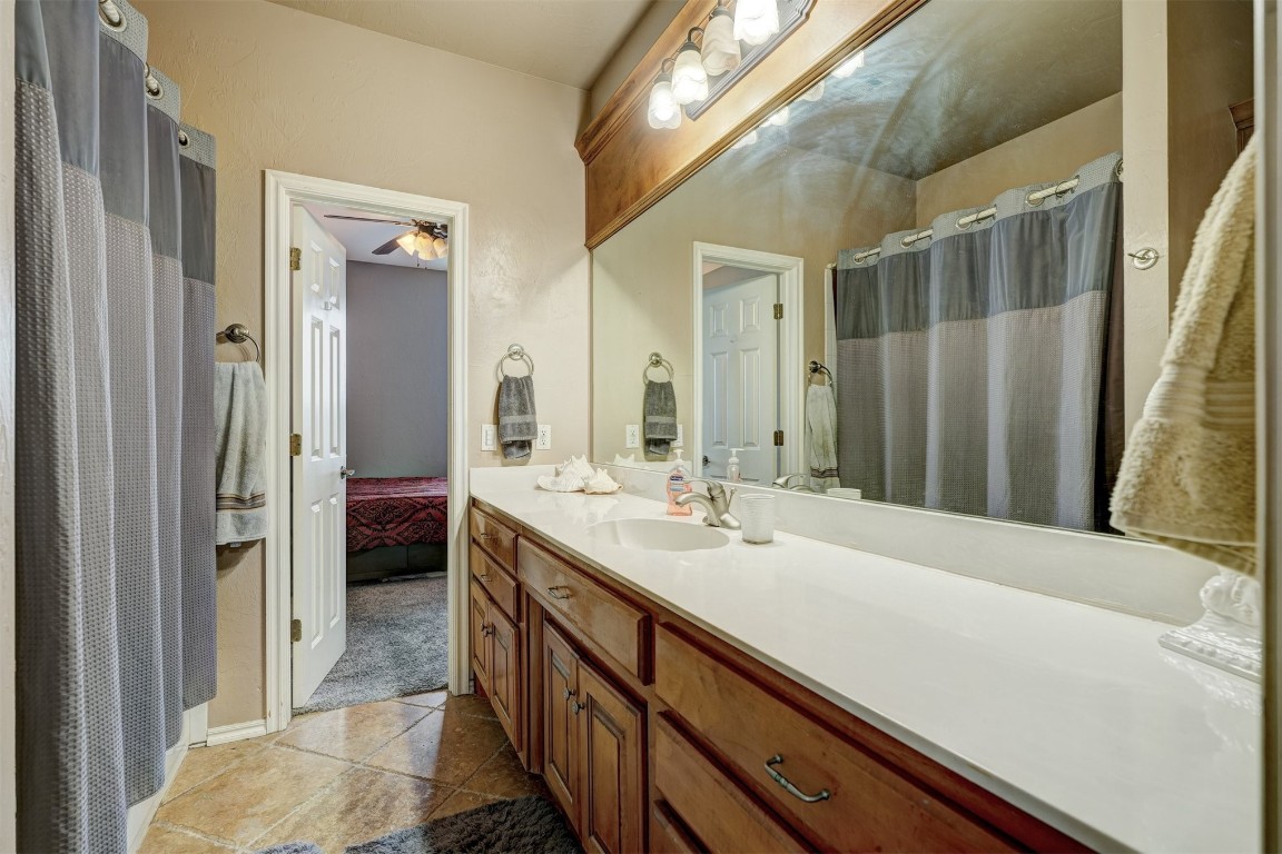12549 Crick Hollow Court, Oklahoma City, OK 73170 bathroom featuring ceiling fan, tile floors, and large vanity