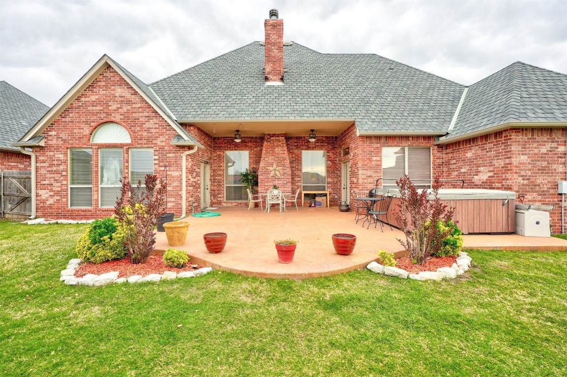 12549 Crick Hollow Court, Oklahoma City, OK 73170 back of property with a hot tub, a patio, a yard, and ceiling fan