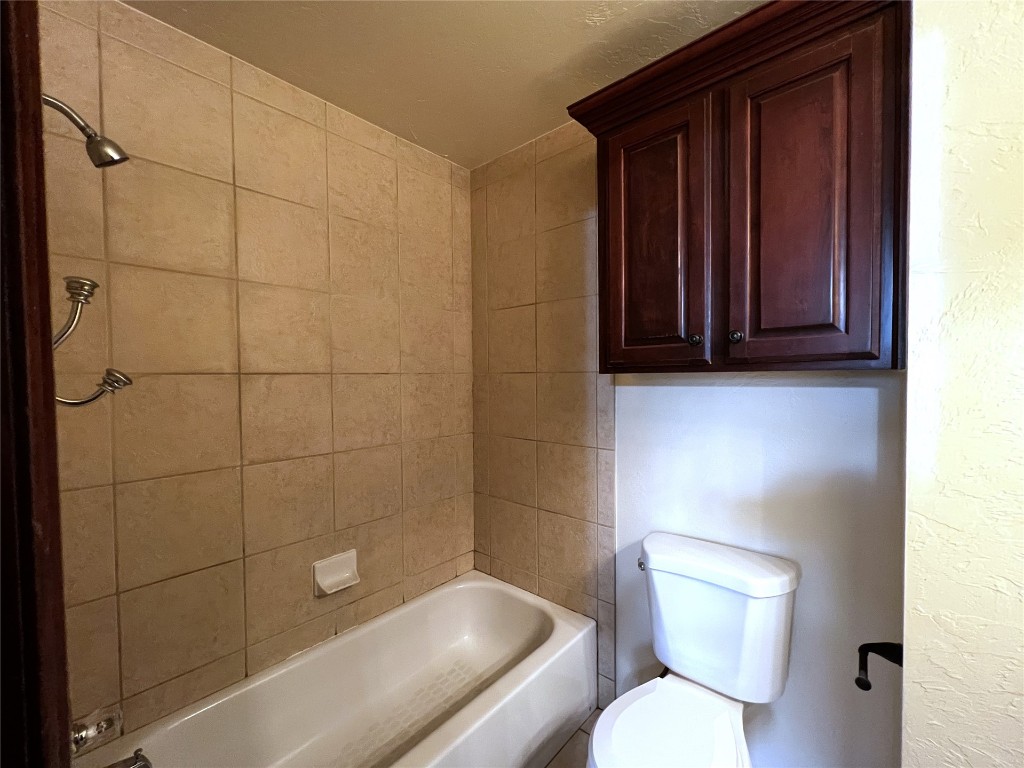 16416 Grace Anne Court, Edmond, OK 73013 bathroom with tiled shower / bath combo and toilet