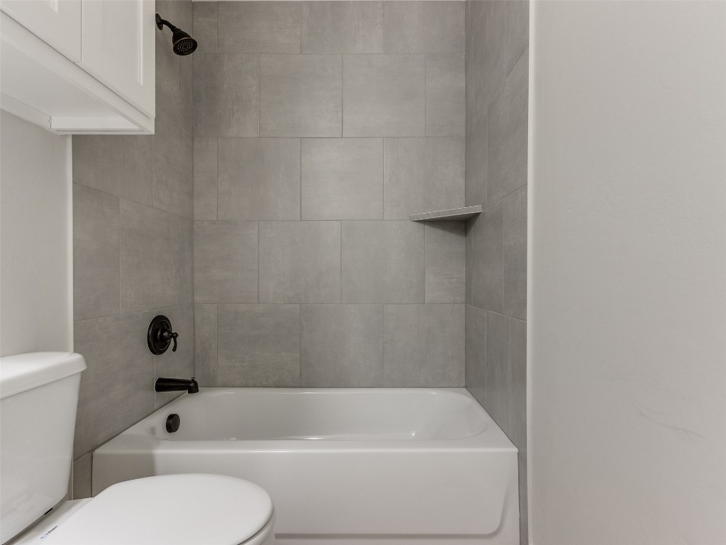 9009 NE 139th Street, Jones, OK 73049 bathroom with tiled shower / bath combo and toilet