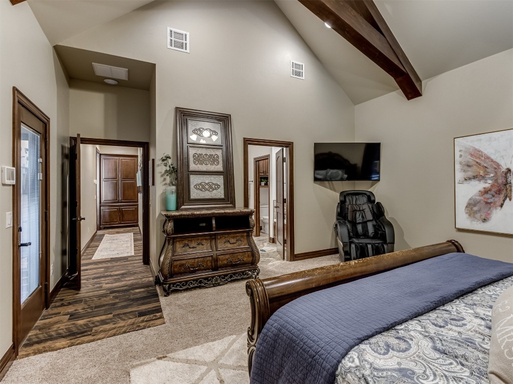 9701 Nawassa Drive, Midwest City, OK 73130 carpeted bedroom featuring high vaulted ceiling, ensuite bath, and beam ceiling