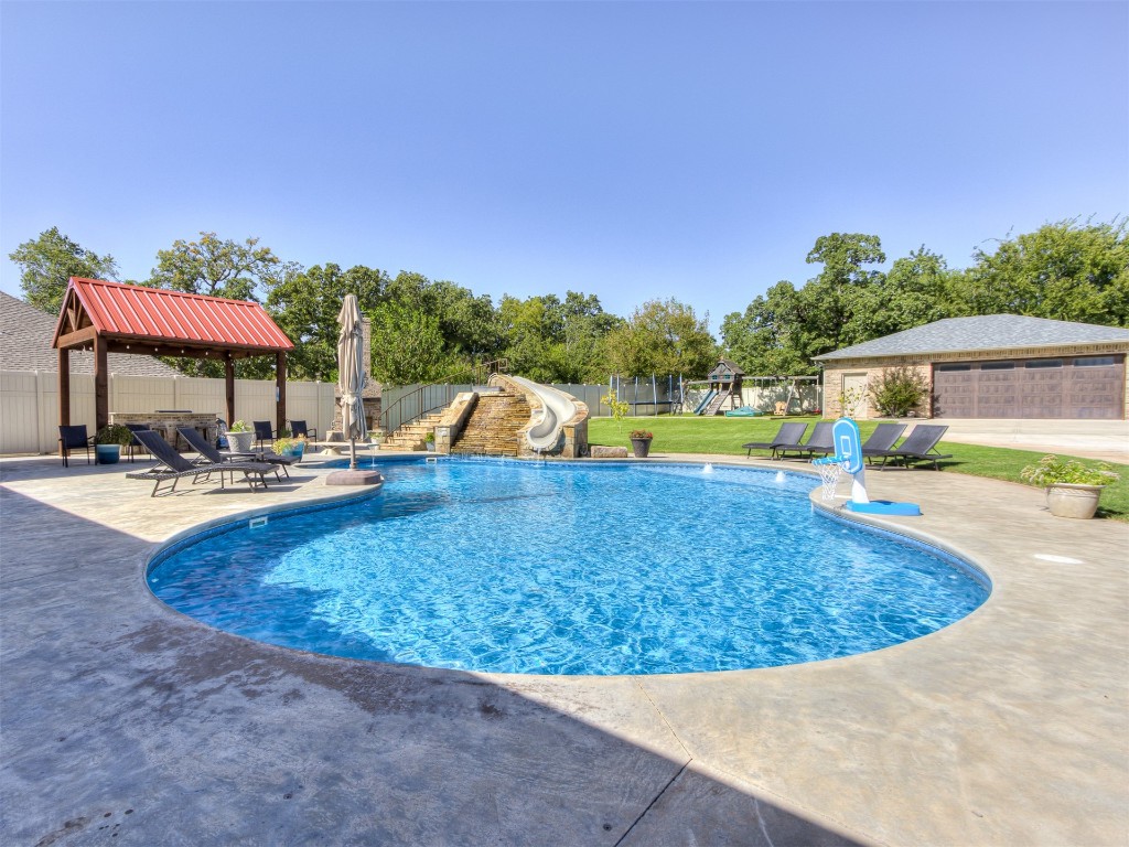 9701 Nawassa Drive, Midwest City, OK 73130 view of swimming pool featuring a water slide, a yard, and a patio