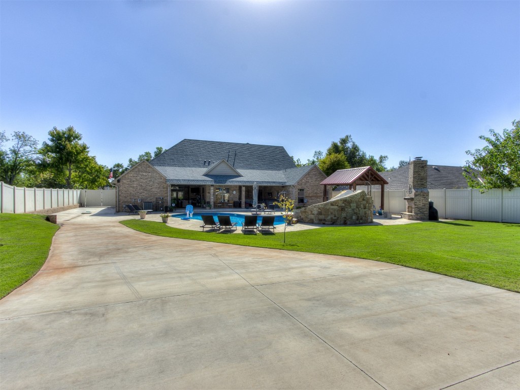 9701 Nawassa Drive, Midwest City, OK 73130 view of front of home featuring a front lawn, a patio, and a fenced in pool