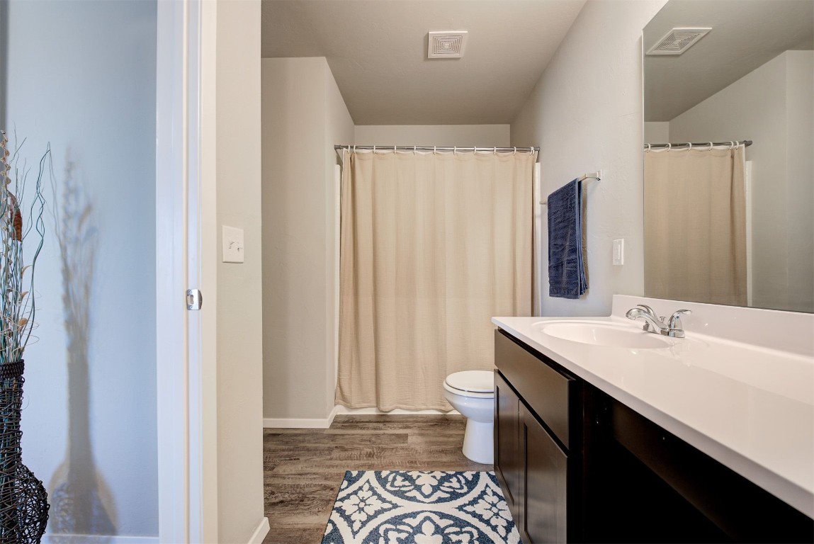 1821 Oxen Lane, El Reno, OK 73036 bathroom with wood-type flooring, vanity with extensive cabinet space, and toilet
