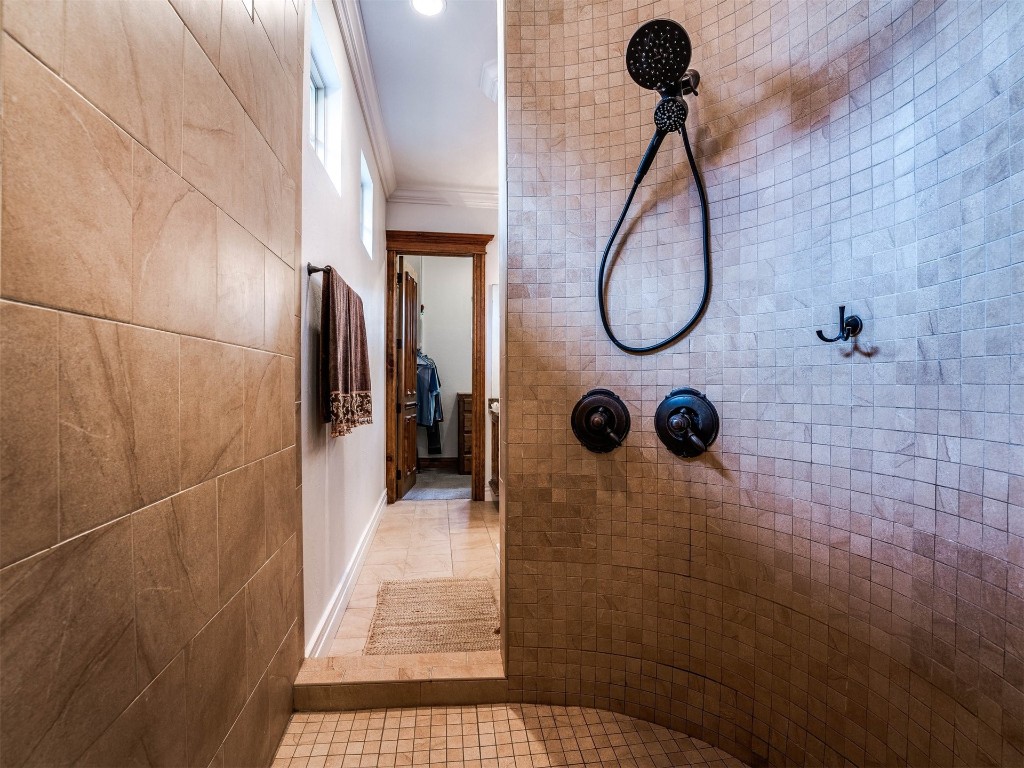5501 NW 132nd Street, Oklahoma City, OK 73142 bathroom with ornamental molding, tile flooring, and a tile shower