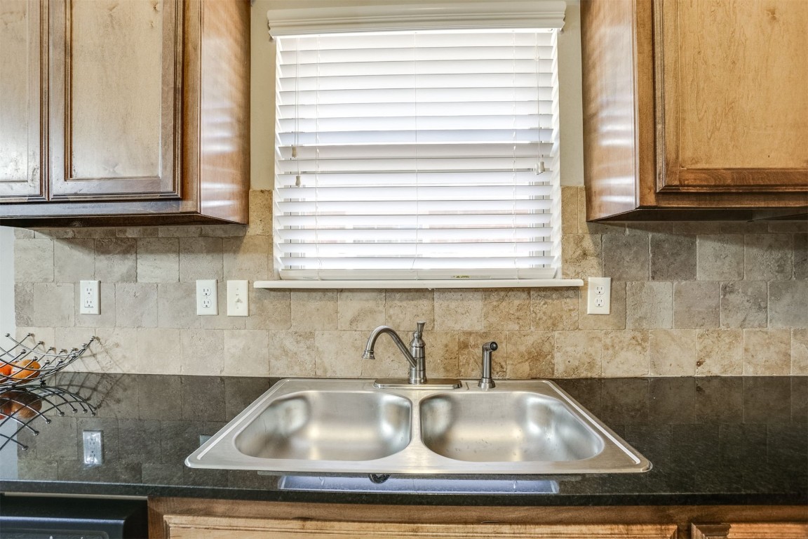 Address Hidden kitchen featuring sink and tasteful backsplash