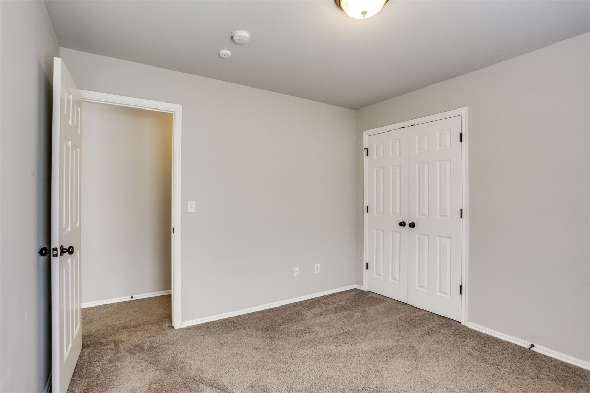 Address Hidden unfurnished bedroom with dark colored carpet and a closet