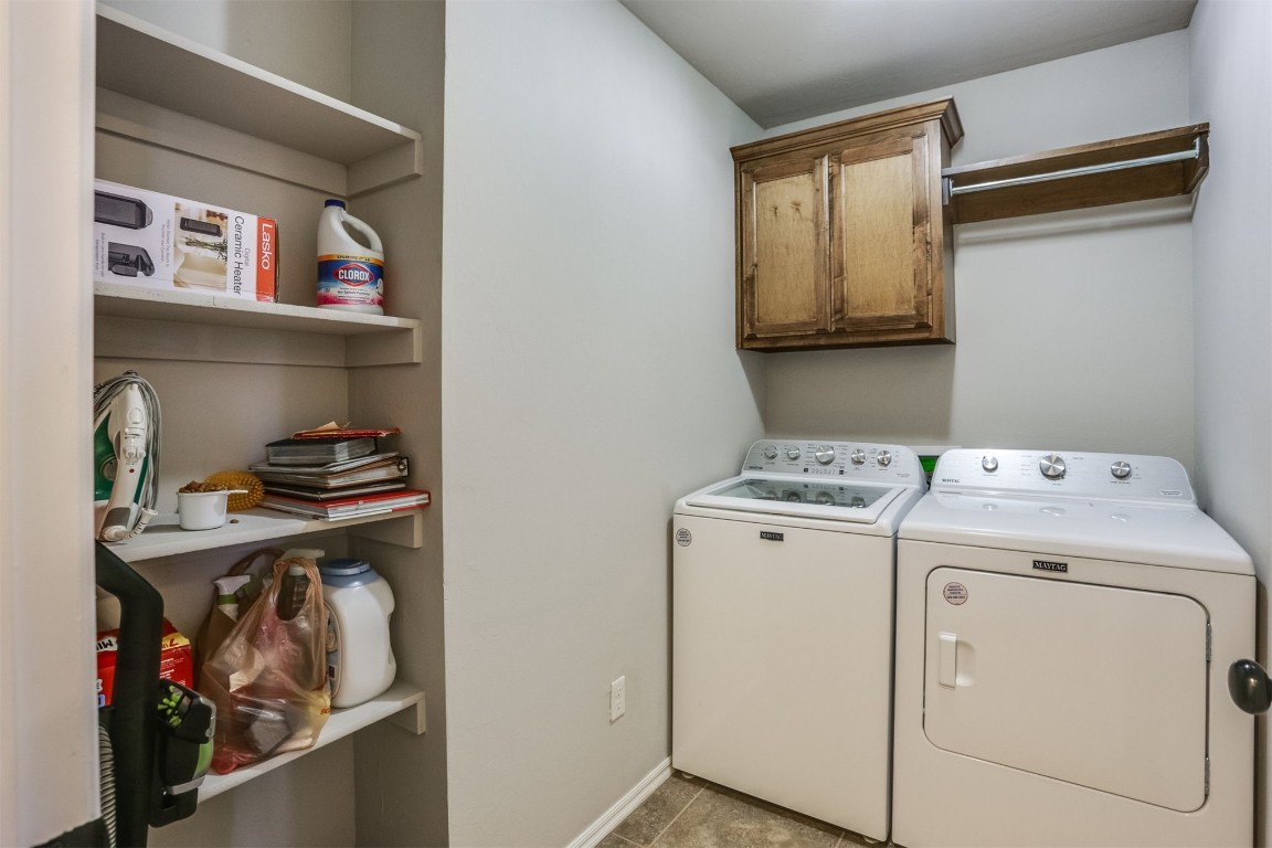 Address Hidden clothes washing area with cabinets, light tile floors, and washer and clothes dryer