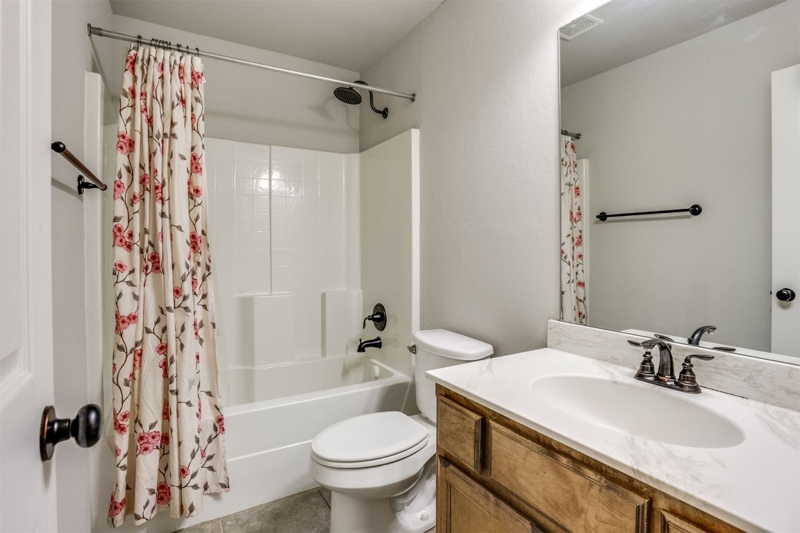 Address Hidden full bathroom featuring tile flooring, vanity, toilet, and shower / bathtub combination with curtain