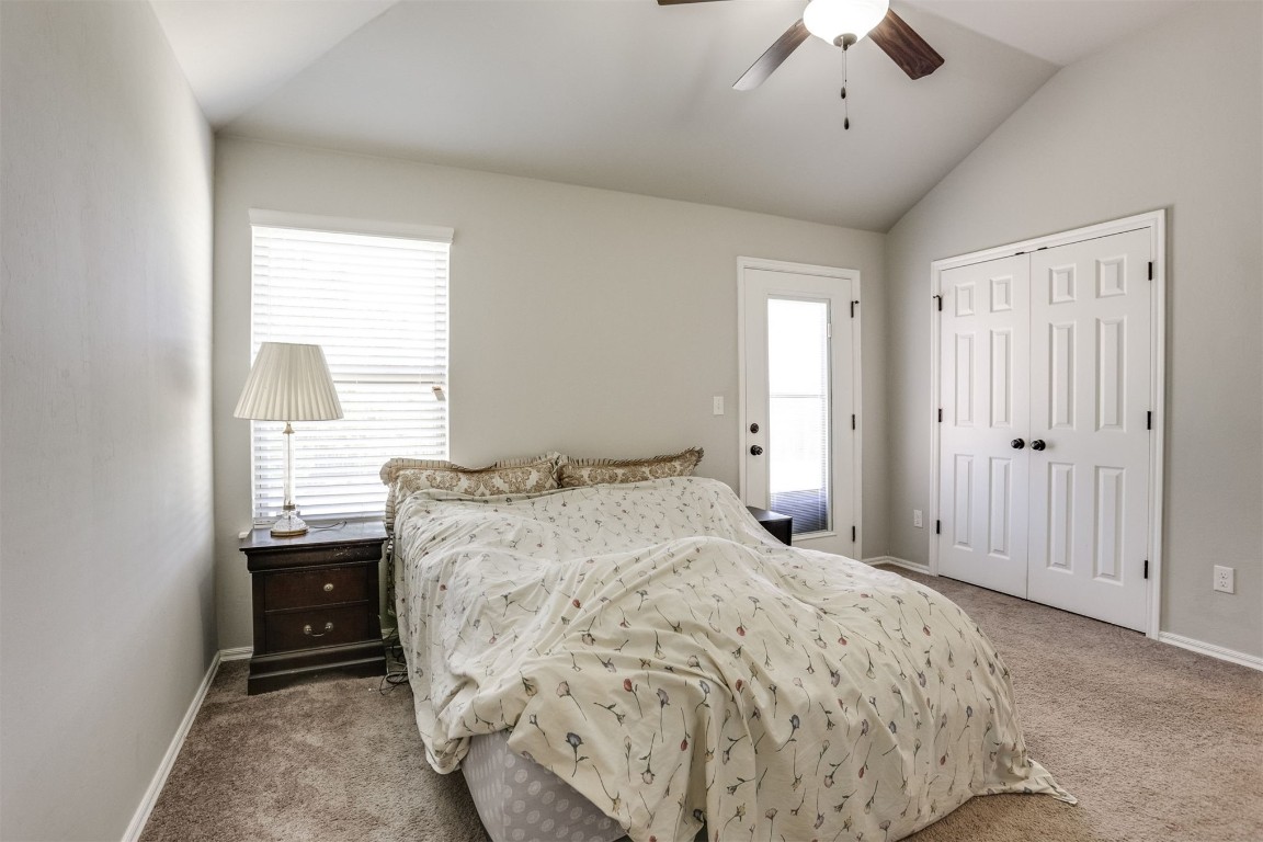 Address Hidden bedroom featuring light carpet, vaulted ceiling, ceiling fan, and a closet