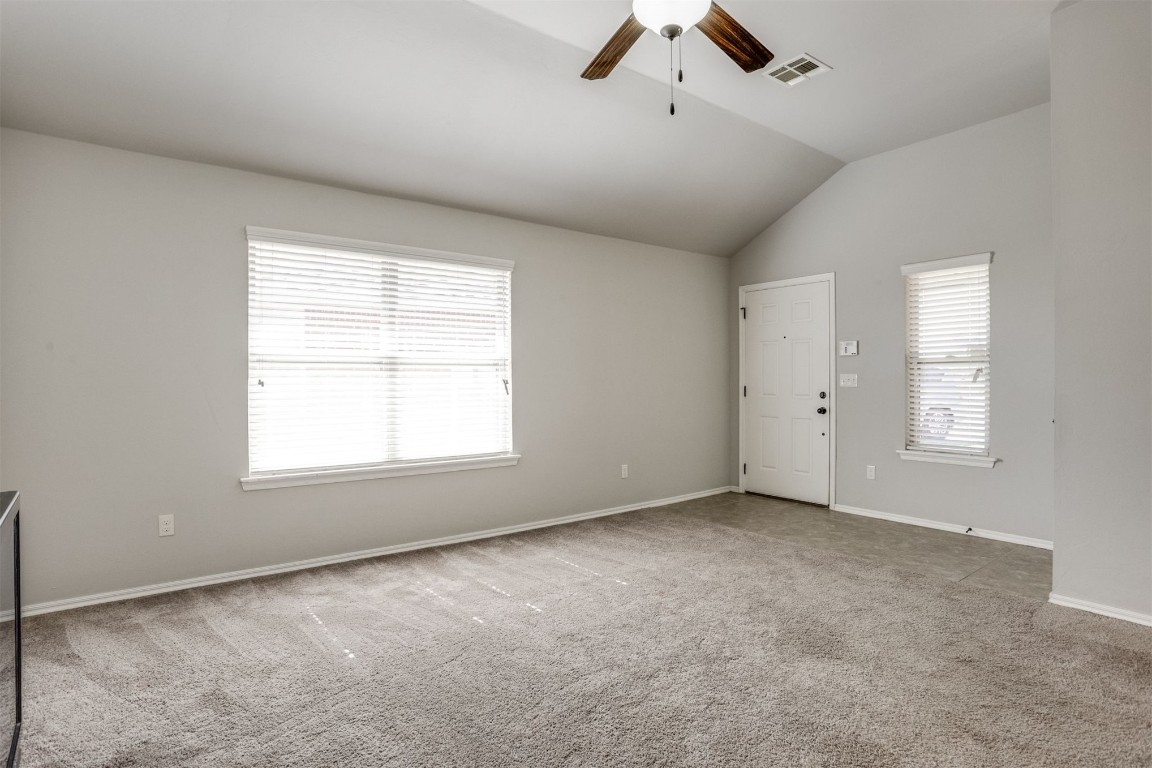 Address Hidden carpeted empty room featuring vaulted ceiling, plenty of natural light, and ceiling fan