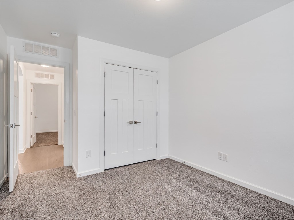 10416 NW 34th Street, Yukon, OK 73099 unfurnished bedroom featuring a closet and light carpet