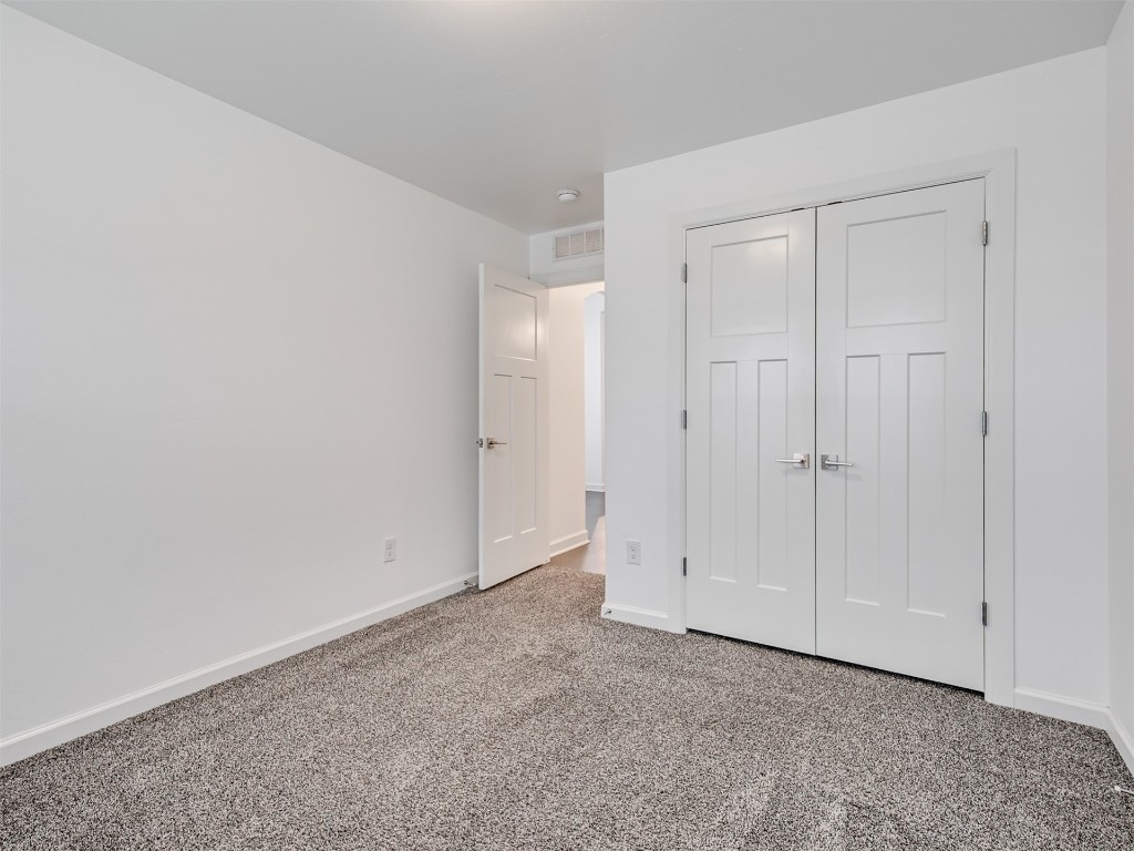 10416 NW 34th Street, Yukon, OK 73099 unfurnished bedroom with a closet and light carpet