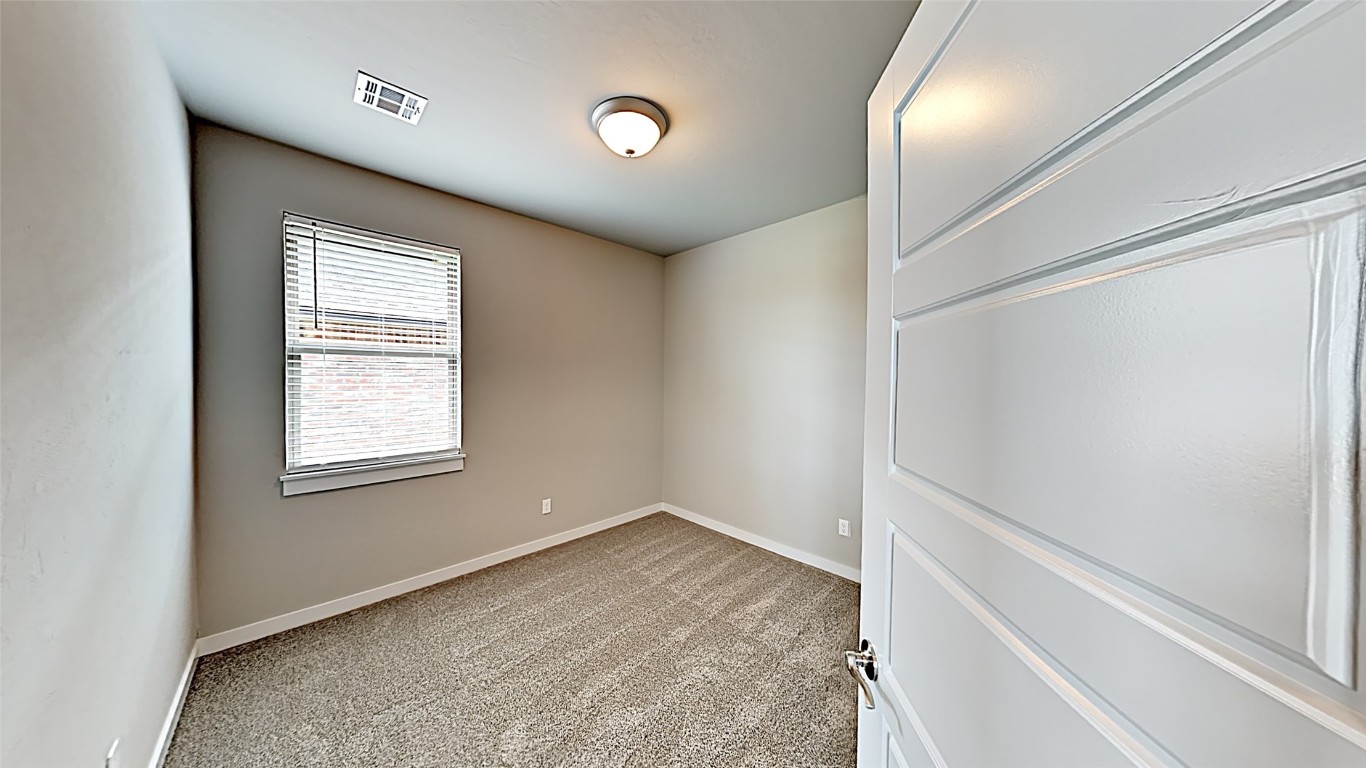 416 Charles Court, Yukon, OK 73099 spare room featuring light colored carpet