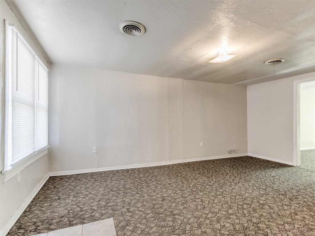 4900 S Blackwelder Avenue, Oklahoma City, OK 73119 carpeted spare room featuring a textured ceiling